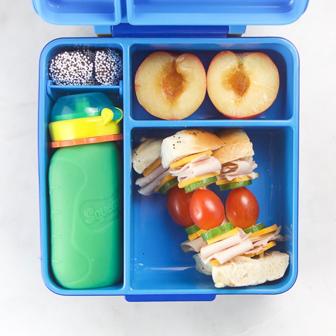 Blue school lunch box filled with healthy foods for kids.