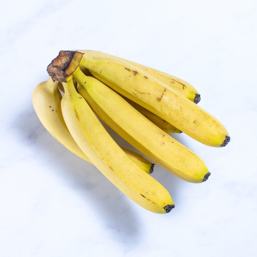 A bunch of bananas on a marble countertop.