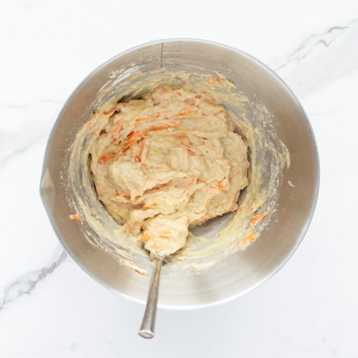 A silver mixing bowl with the batter for ABC muffins for baby and toddler.