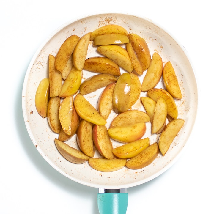 White skillet with apple slices for baby.