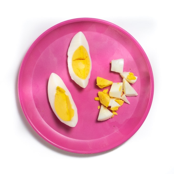 Pink baby plate filled with two way to serve hard boiled eggs.