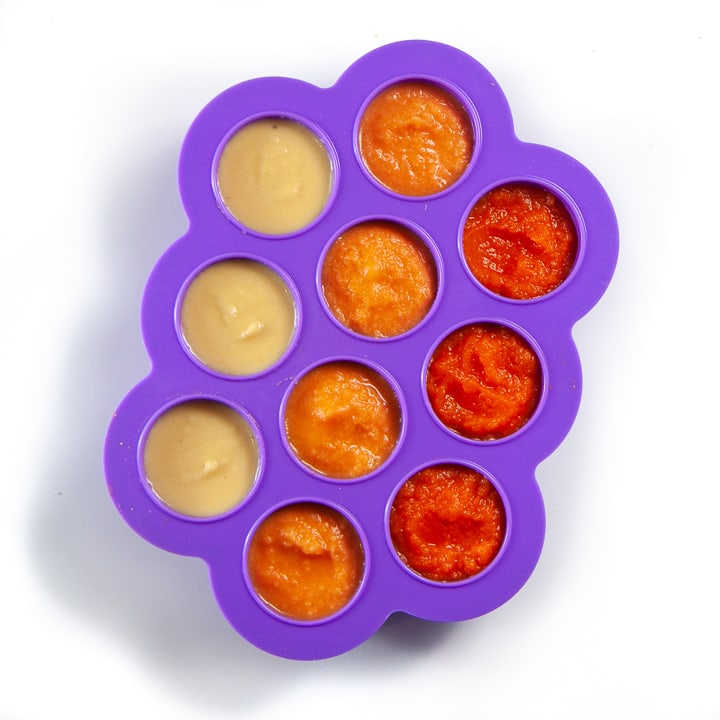 Purple baby food storage container with three different baby purees inside.