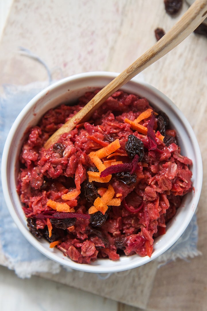 Small white bowl filled with a bright pink oatmeal for toddler.