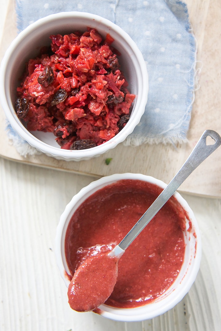 Two small white bowls - one filled with a chunky red oatmeal and the other filled with a smooth oatmeal for baby.