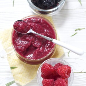 Spread of glass bowls filled with produce and a homemade baby food puree.