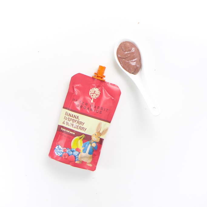 brand pouch with a spoon filled with it's puree