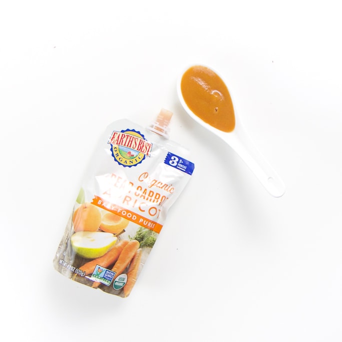 organic baby food brand pouch with a spoon filled with it's puree