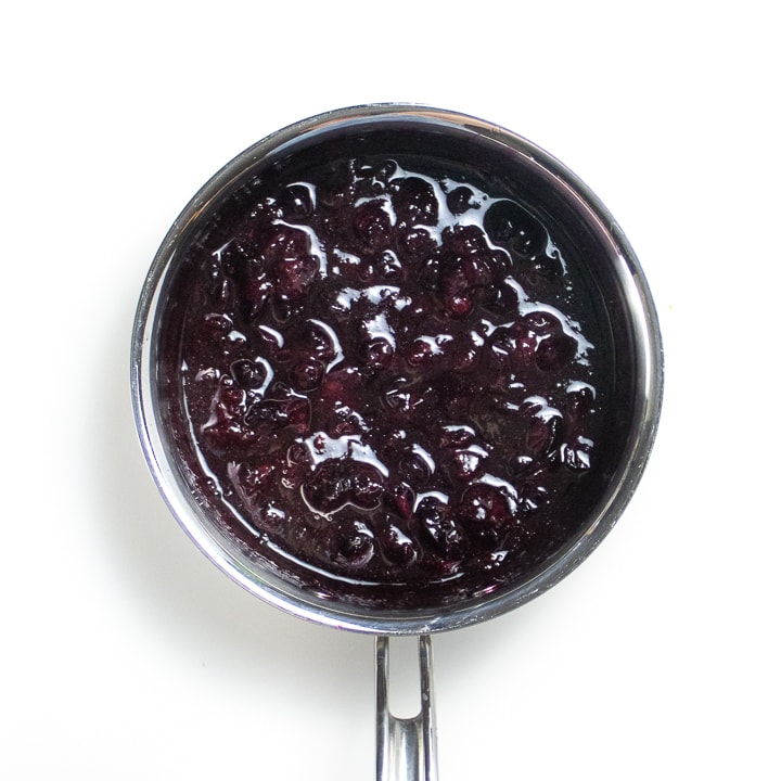 Saucepan full of simmered blueberries. 