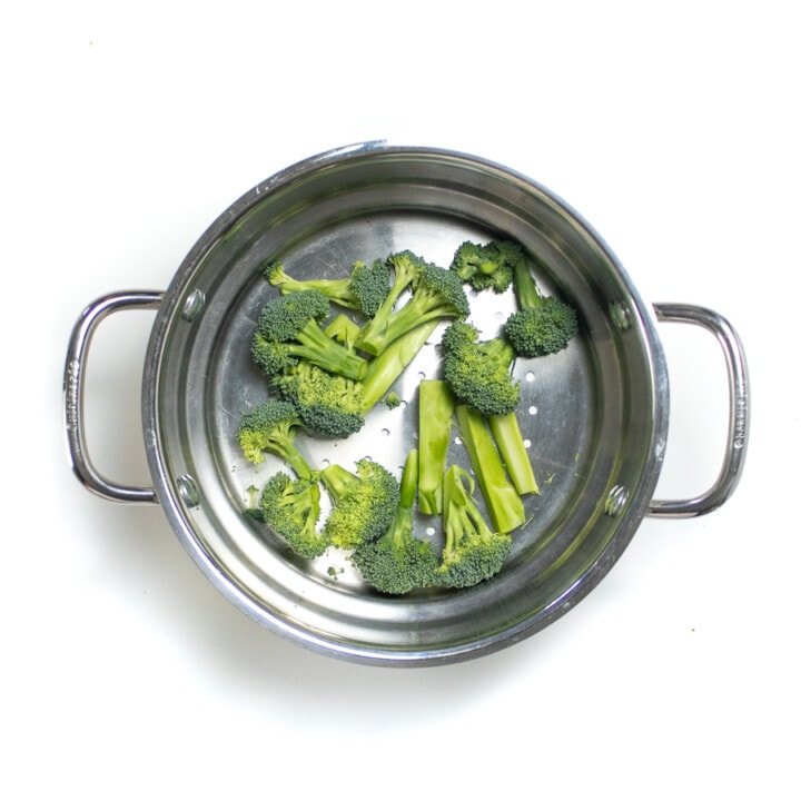 Steamer basket with steamed broccoli.