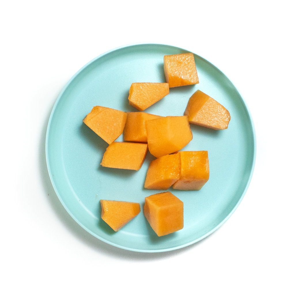 A teal kids play with cubes of Kalab against a white background.