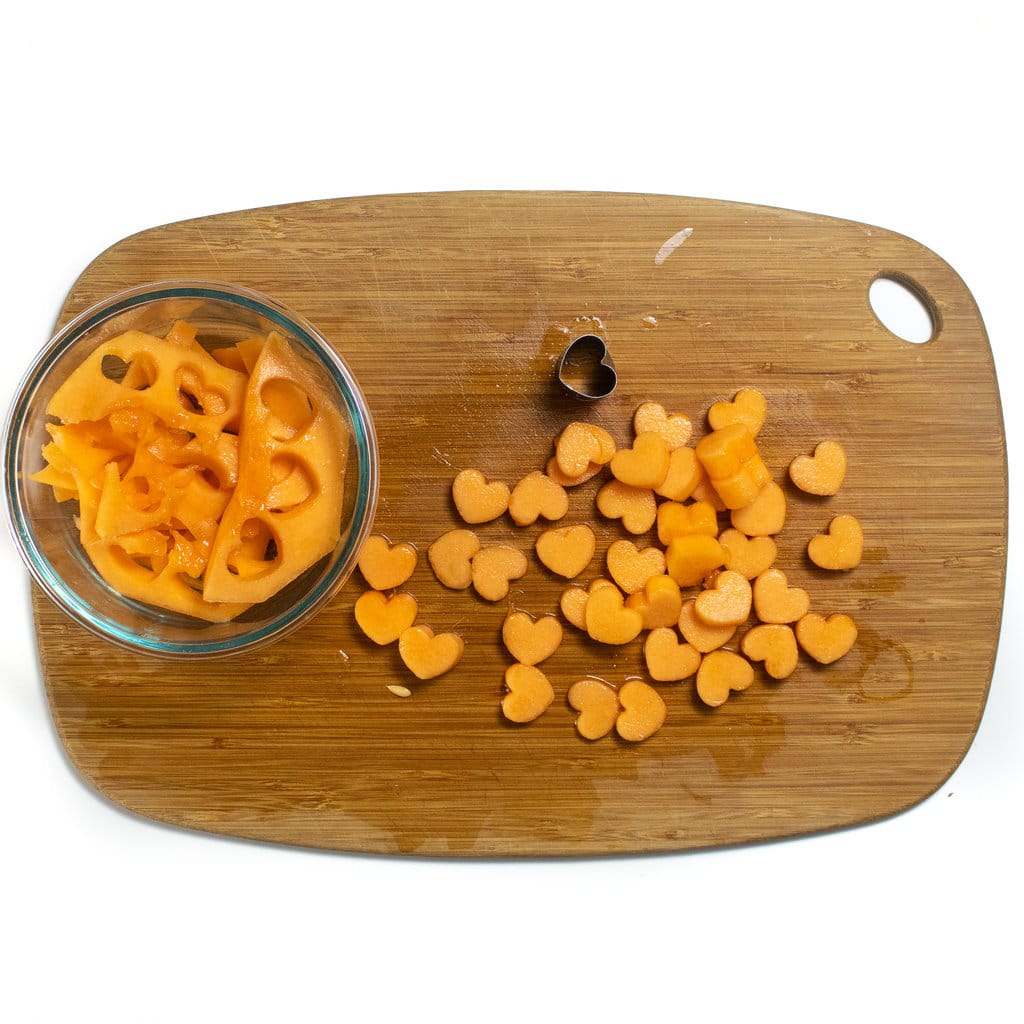 Heart shaped pieces of trim up on a wooden cutting board.