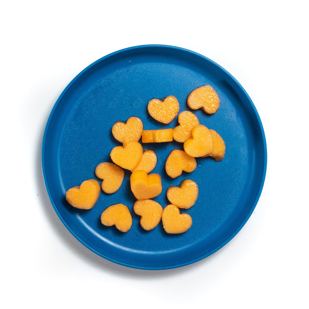 A blue kids play with heart shaped cantaloupe