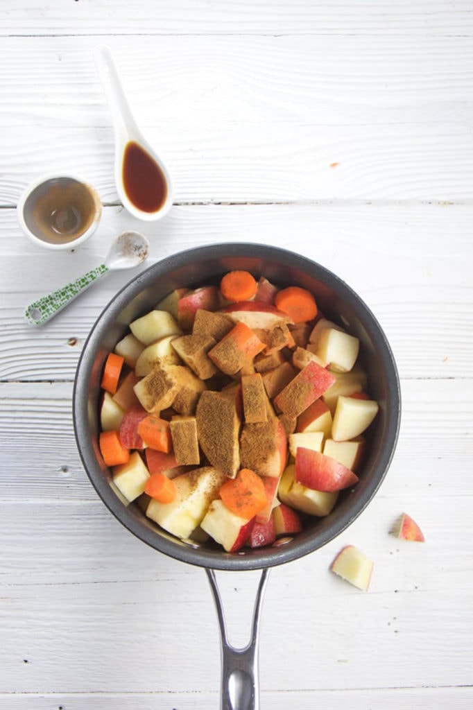 Saucepan is full of chopped produce with the spices sprinkled on top. 