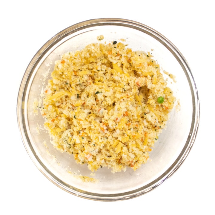 Clear glass bowl against a white background full of color flower mixture for CauliFlower tots.