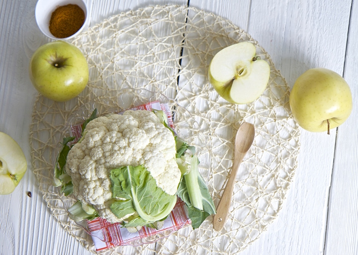 Cauliflower on a white board with napkin underneath it.