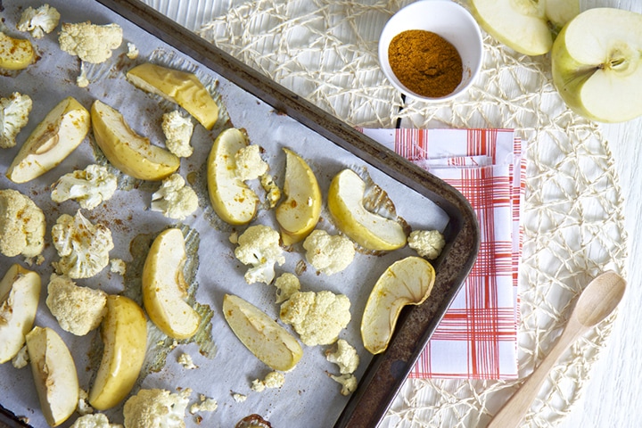 Baking sheet with produce scattered on top.