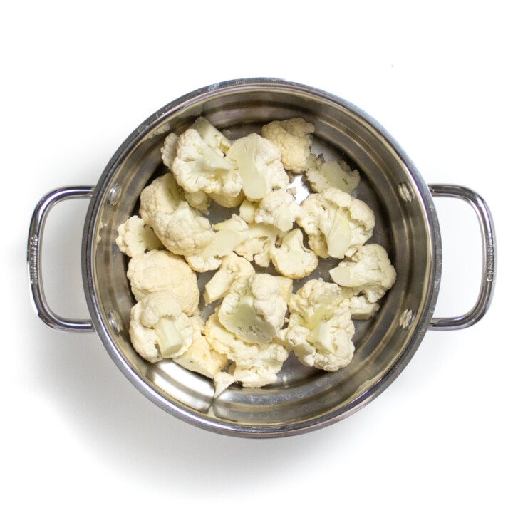 A steamer basket full of cauliflower pieces.