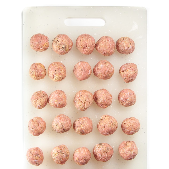 chicken meatballs on a cutting board rolled into balls