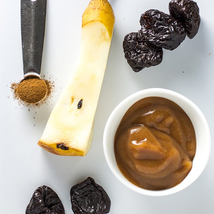 A spread of produce and a small bowl filled with baby food puree. 