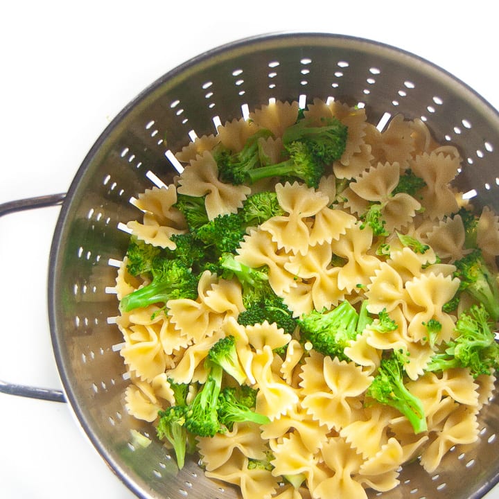 Colander with strained pasta and broccoli