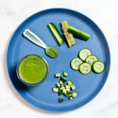 A blue baby plate with different ways to serve cucumber to your baby on a white counter in my kitchen.