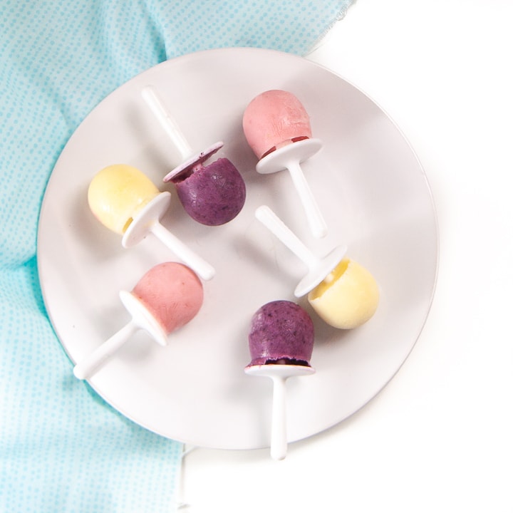 plate filled with yogurt popsicles in three different flavors.