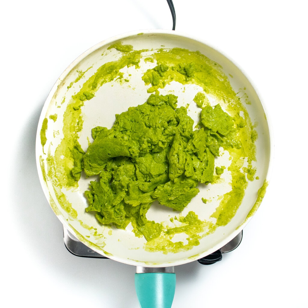 He large skillet with green scrambled eggs, cooked and ready to serve.