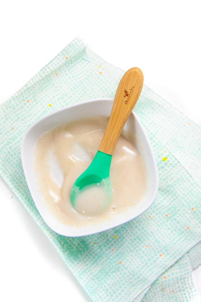 Small white bowl filled with pureed homemade rice cereal for baby.