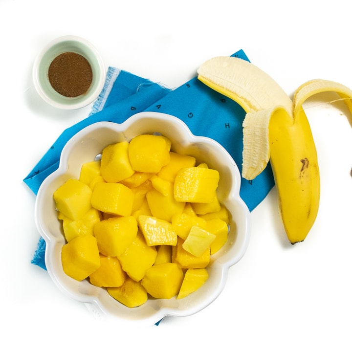 Spread of ingredients for mango baby food puree - mango, banana, nutmeg.