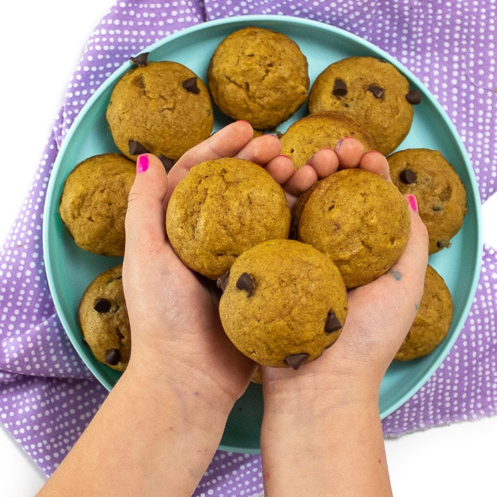 Small kids hands holding mini muffins. 