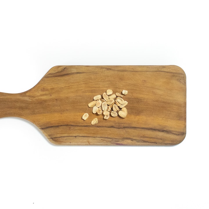 Cutting board with peanut on it.