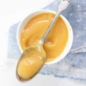 Small white bowl filled with a peach and cauliflower baby food puree.