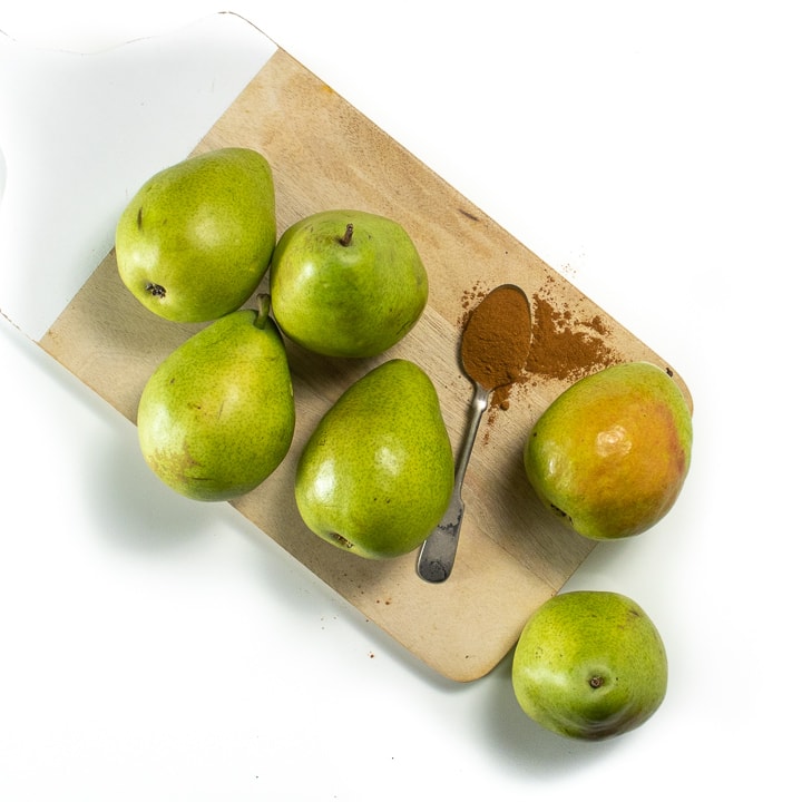 Pears and spices sitting on a cutting board.