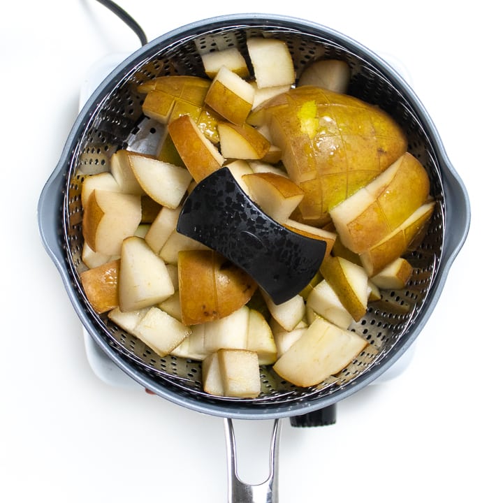 Steamer basket with cooked pears for baby puree.