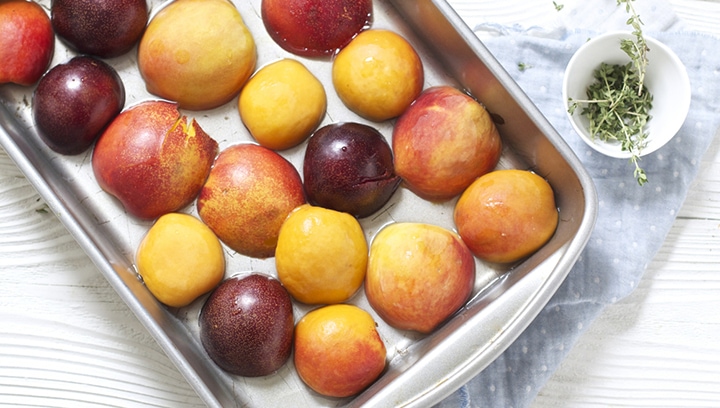 Stone fruit inside of a baking dish.