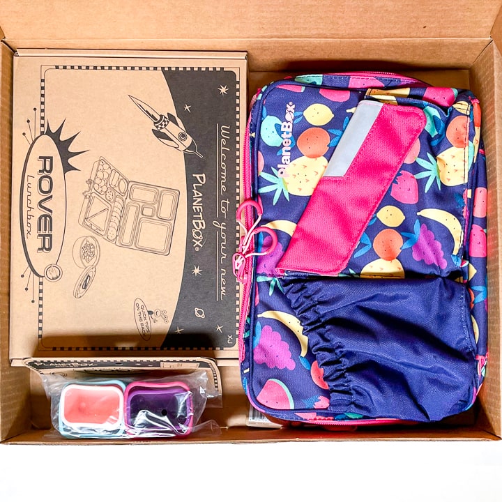 Cardboard box filled with a planetbox, accessories and a carrying case.