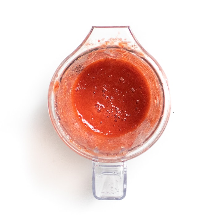 Small blender with pureed strawberries.