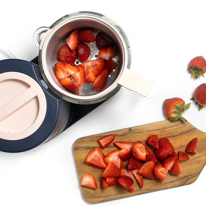 Beaba babycook with a cutting board with chopped strawberries.