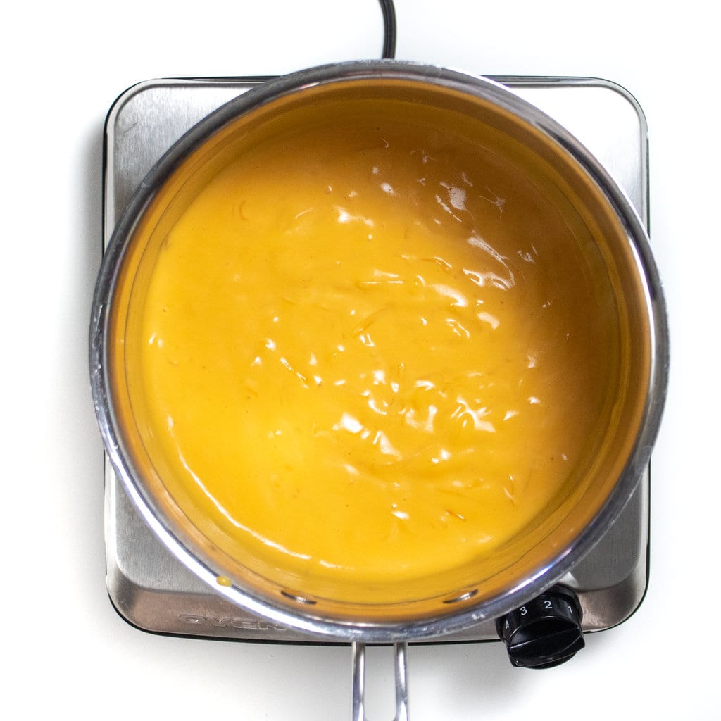 Hey silver sauce pan with melted sweet potato purée, butter and cheese.