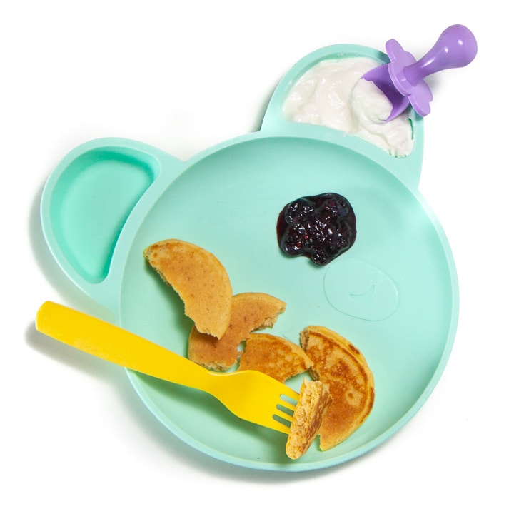 plate full of baby-led weaning pancakes cut into pieces with a fruit dip.