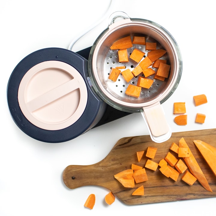 Spread showing Beaba babycook with a cutting board next to it with chopped sweet potato. 