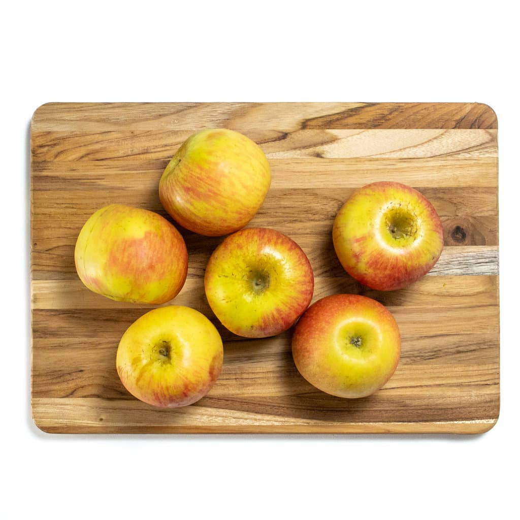 wooden cutting board with apples on top.