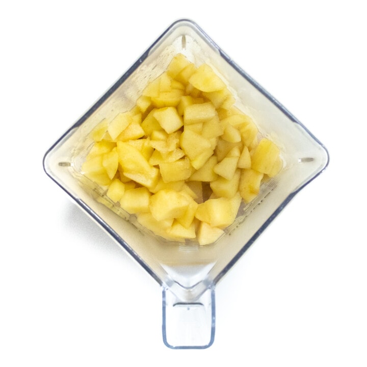 Clear blender with cooked apples.