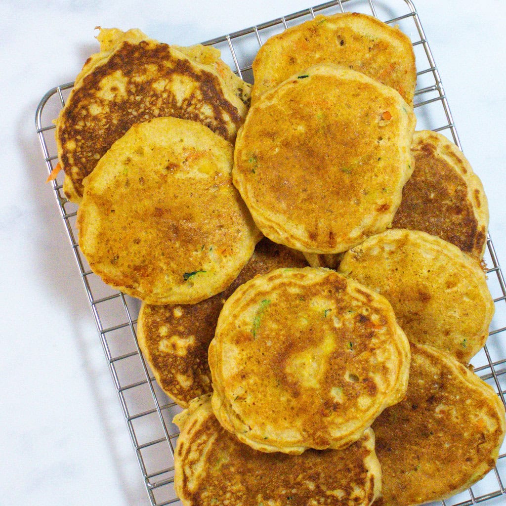 A wire cooling rack on my kitchen counter with a stack of veggie pancakes for baby toddler and kids.