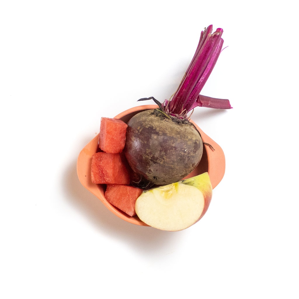 A peach baby bowl filled with a beet apple and watermelon.