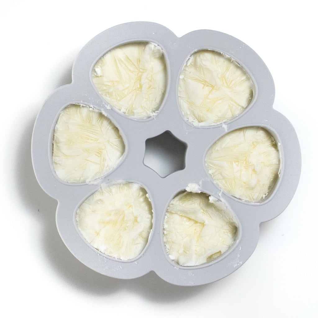 Ice cube tray with frozen yogurt inside against the way backgrounds.