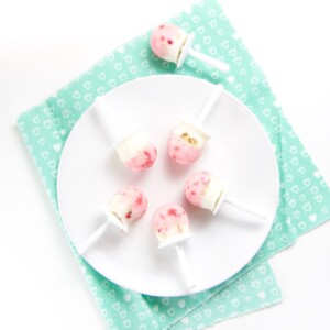 White plate with 5 healthy yogurt parfait popsicles in a circle.