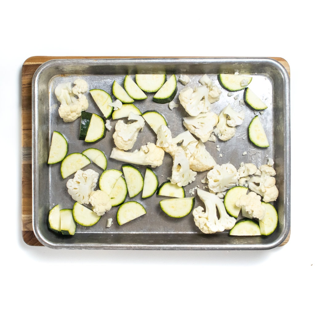 It's silver baking sheet with cut zucchini and cauliflower.